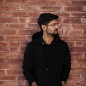 a man standing in front of a brick wall